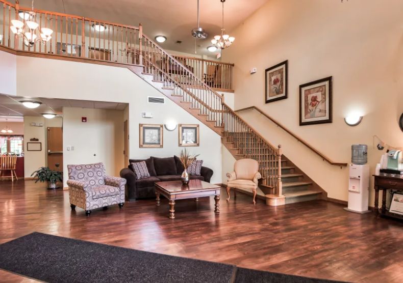 A cozy lobby area featuring comfortable seating and a stylish staircase.