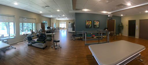 A spacious rehabilitation therapy room equipped with exercise equipment and a bright, inviting atmosphere.