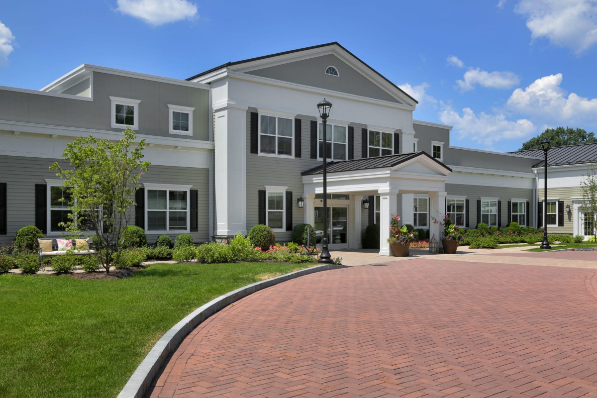 A large building with a welcoming entrance surrounded by well-maintained landscaping and a curved driveway.