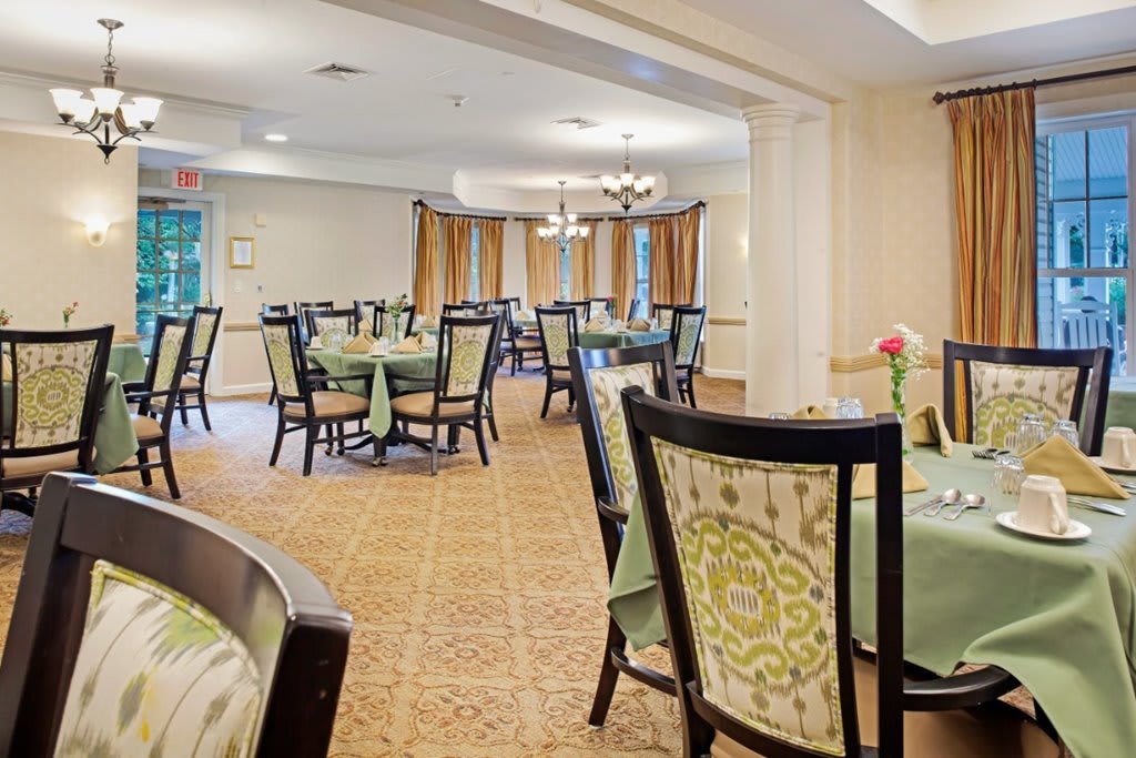 An elegantly furnished dining room with neatly arranged tables and chairs.