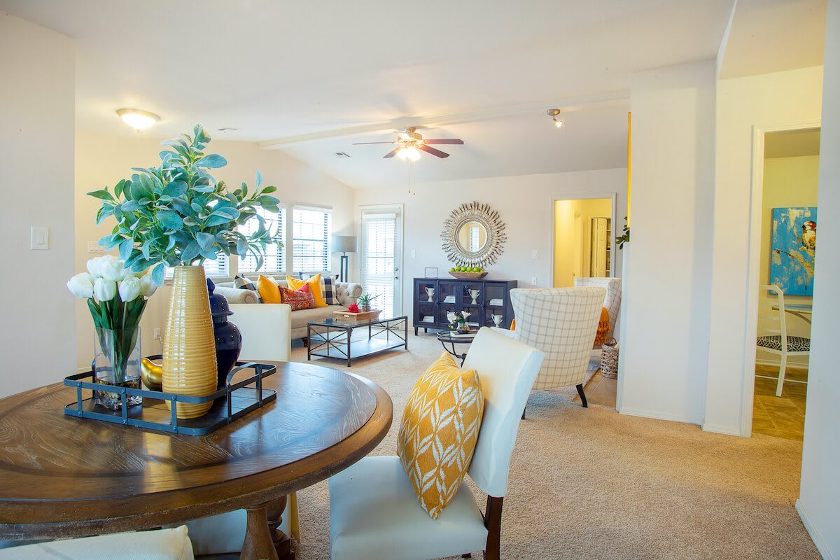 A modern living room with a dining area featuring contemporary furniture and bright decor.