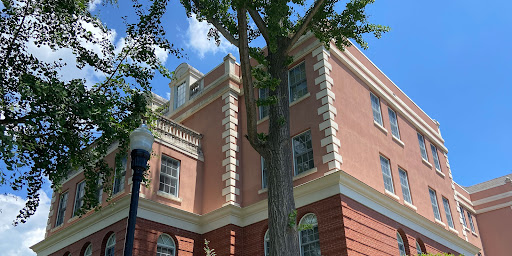 A beautiful architectural building surrounded by greenery against a clear blue sky.