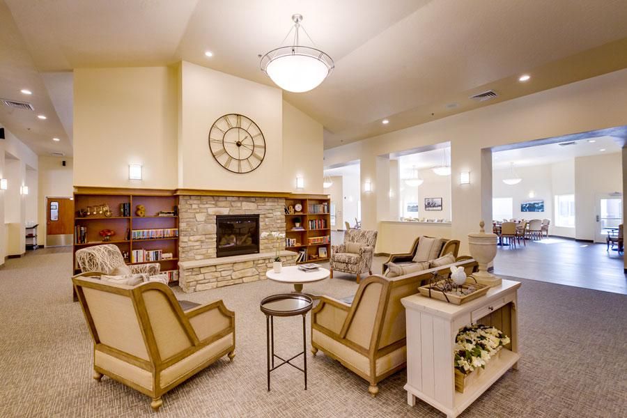 A cozy living room with elegant seating, a fireplace, and bookshelves.