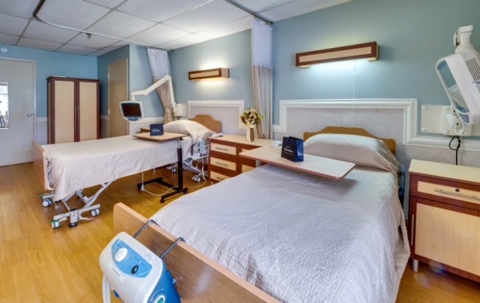 A clean and organized hospital room with two beds, ready for patients.