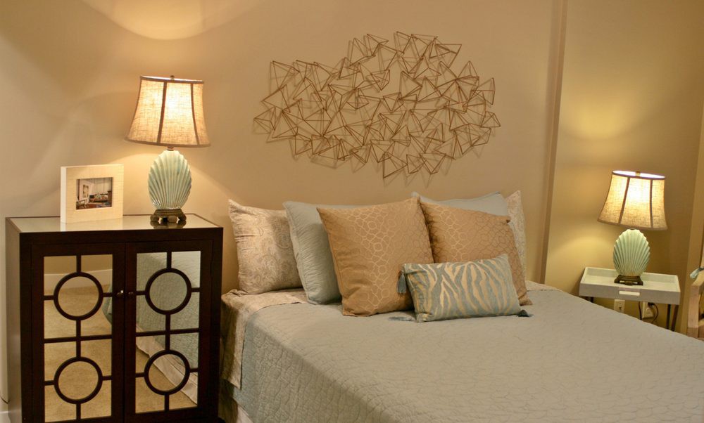 A cozy bedroom with a neatly made bed, decorative pillows, and ambient lighting.