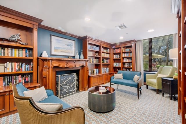 Cozy library room with comfortable seating and wooden bookshelves.