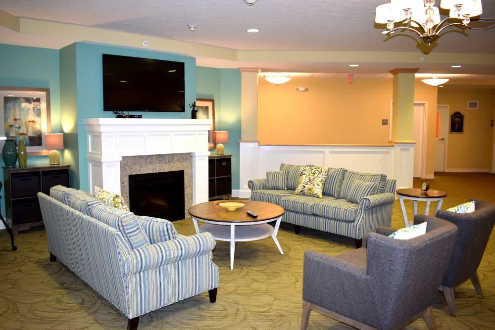 A cozy living room with sofas, a fireplace, and a TV.