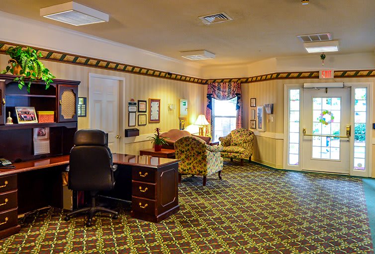 A well-furnished office lobby with a desk, seating area, and decorative elements.