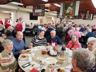 A group of people enjoying a meal together at a community event.
