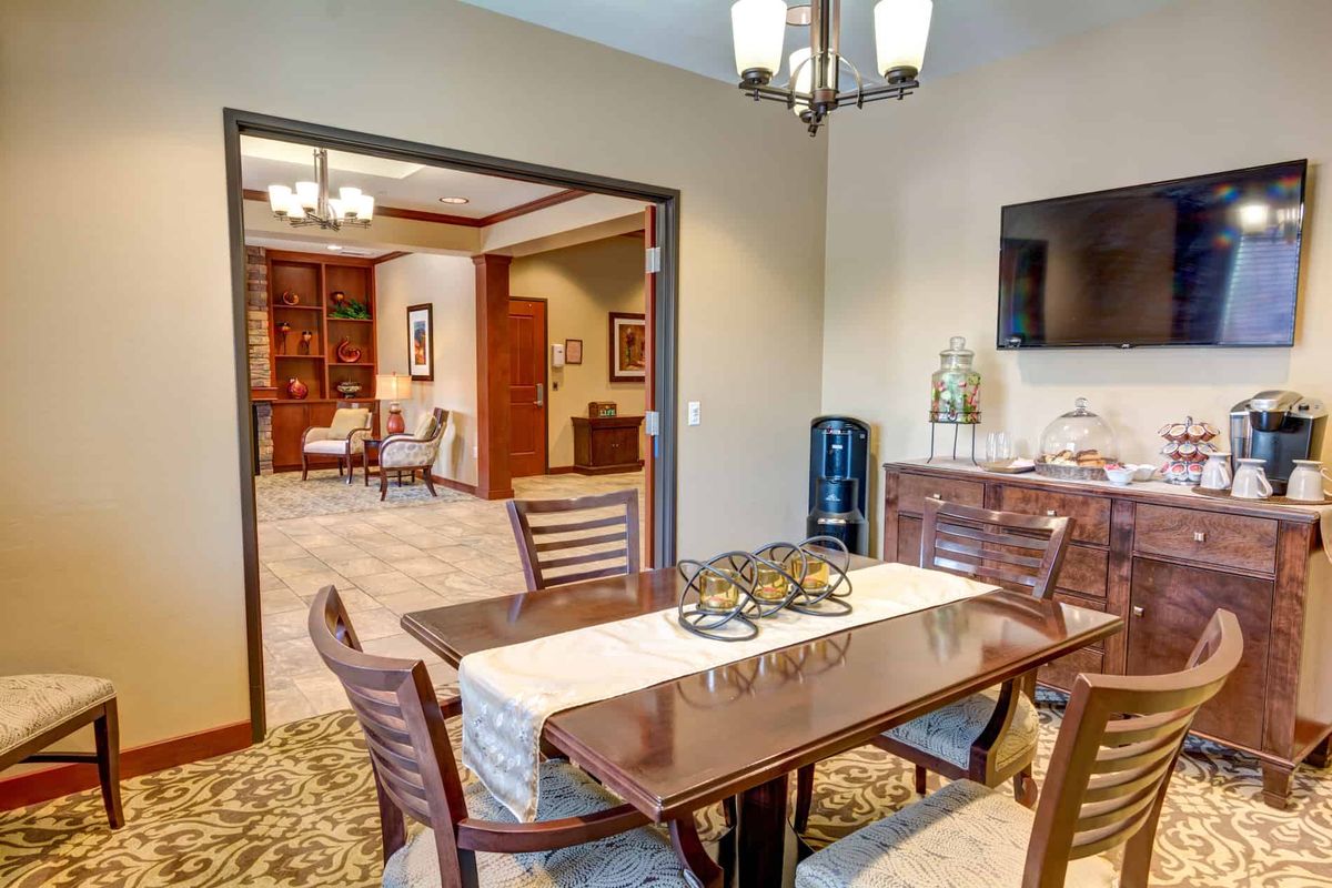 A modern dining room with a wooden table, chairs, and decorative elements.