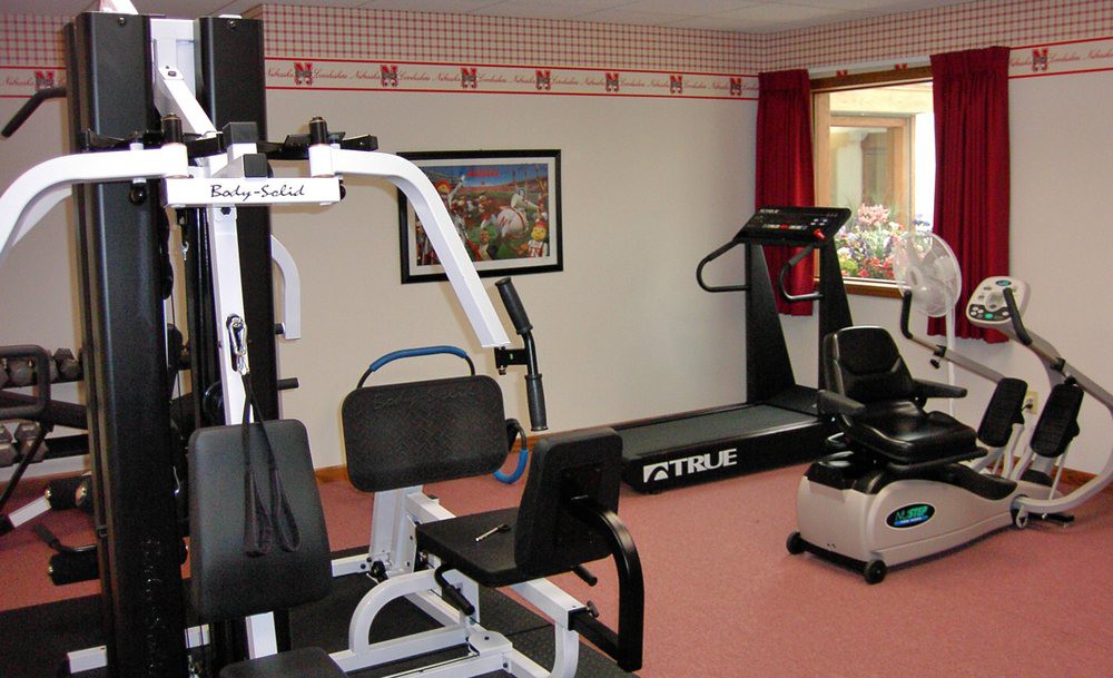 A small indoor gym with various exercise equipment including a treadmill and weight machine.