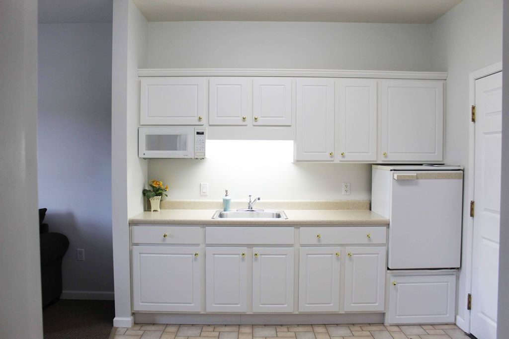 Modern kitchen with white cabinets and appliances.