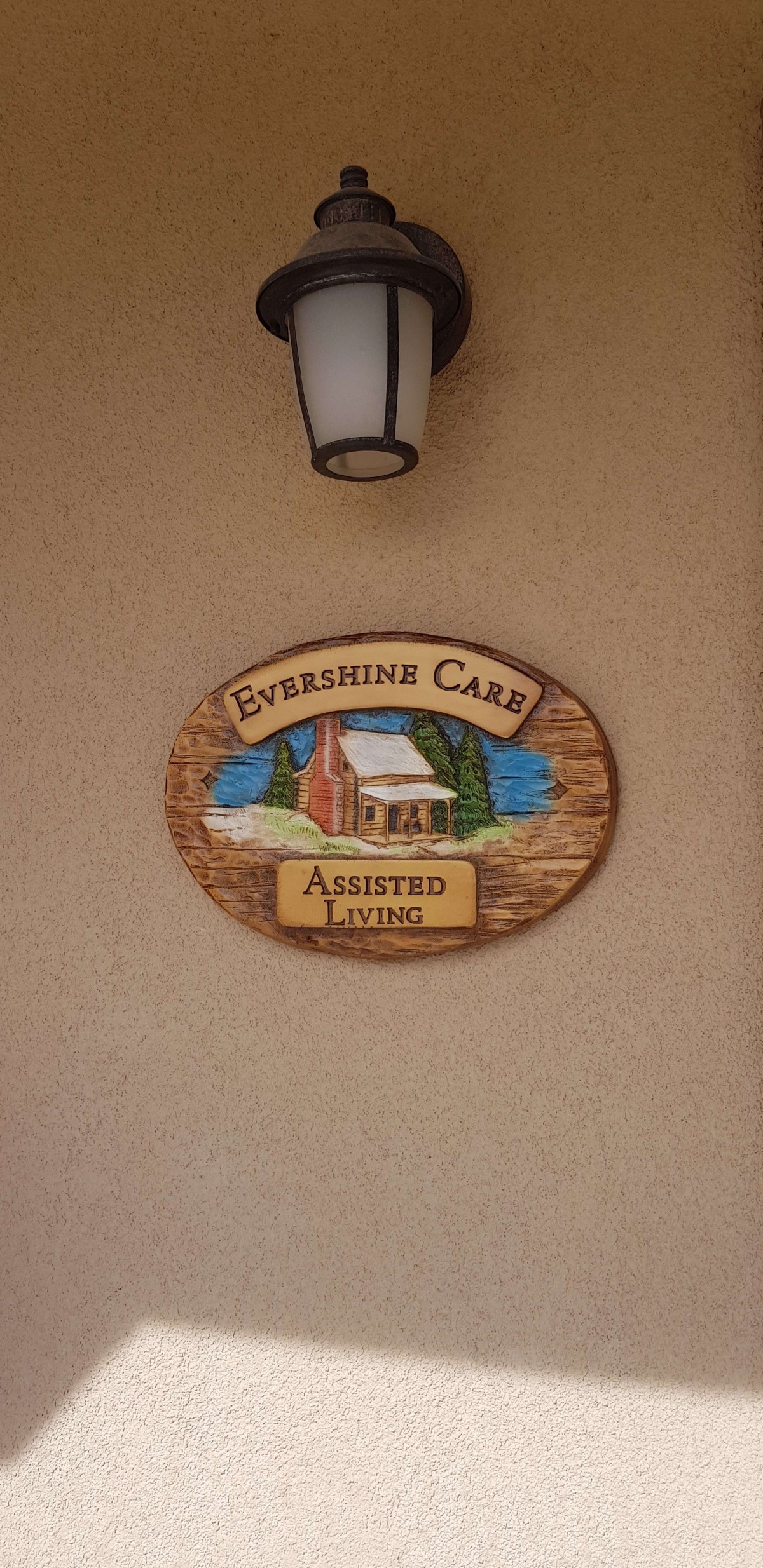 A sign for Evergreen Care Assisted Living on a building exterior.