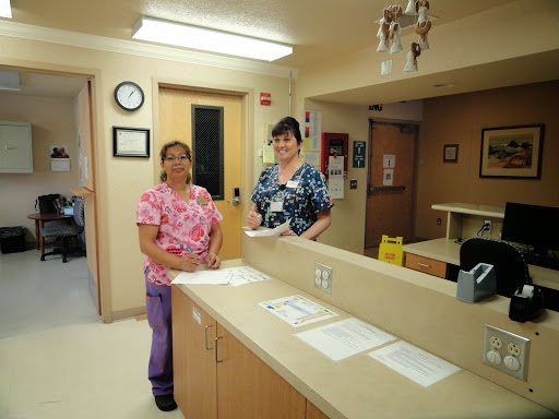 Two healthcare professionals in a hospital reception area.