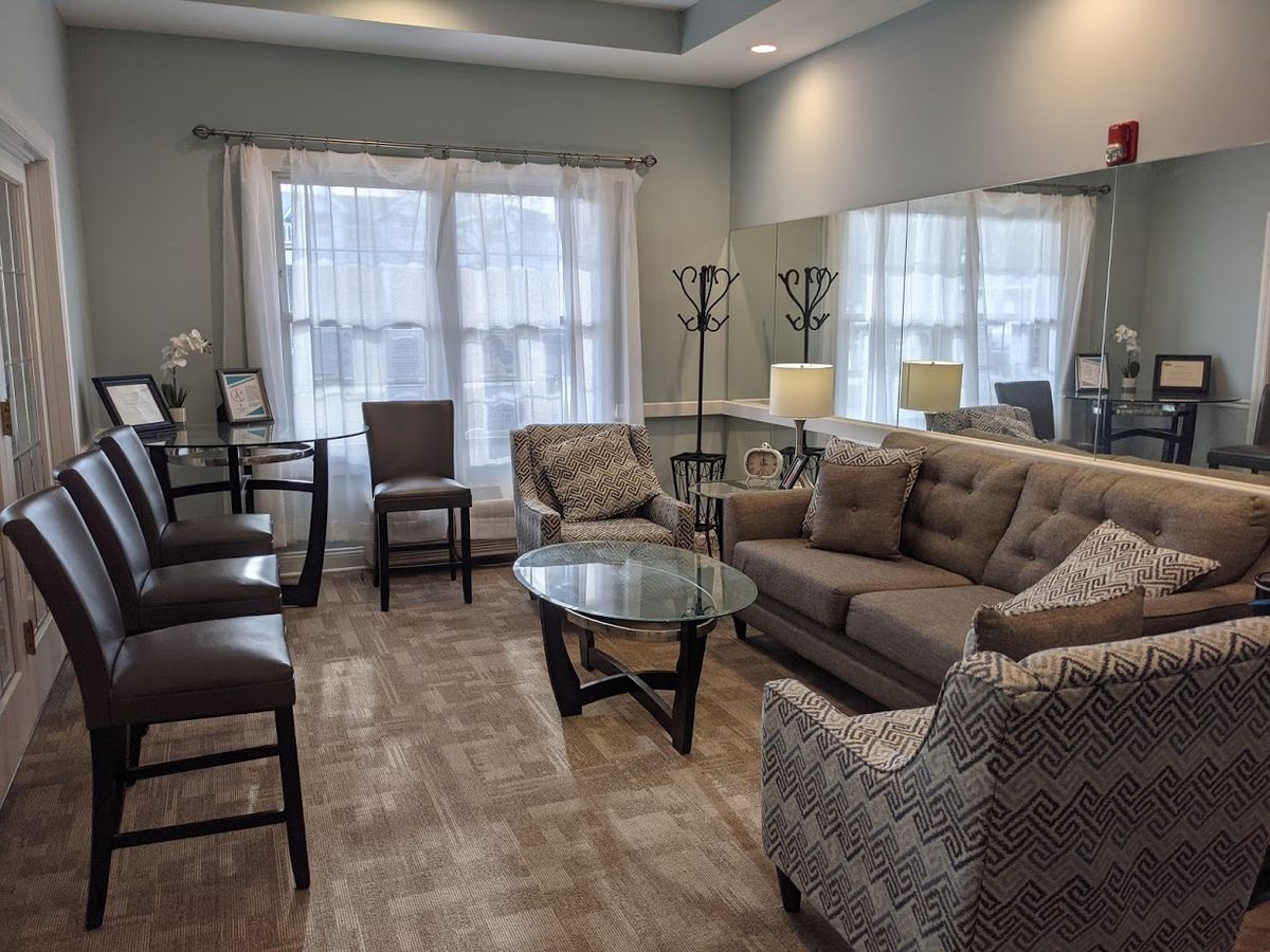 A cozy and modern living room featuring a comfortable sofa, stylish chairs, and a glass coffee table.