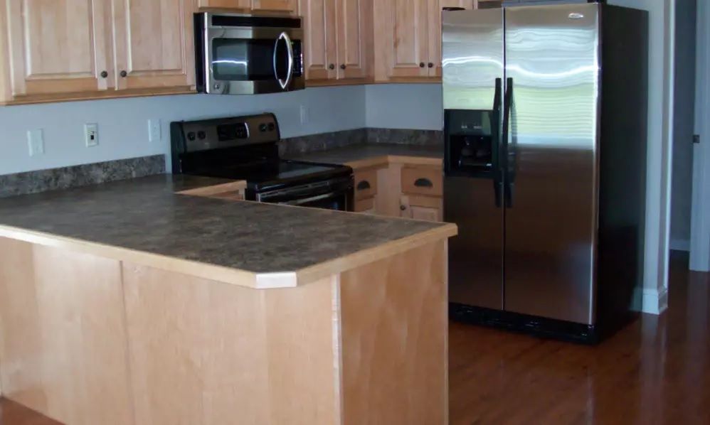 A modern kitchen with wooden cabinets and stainless steel appliances.