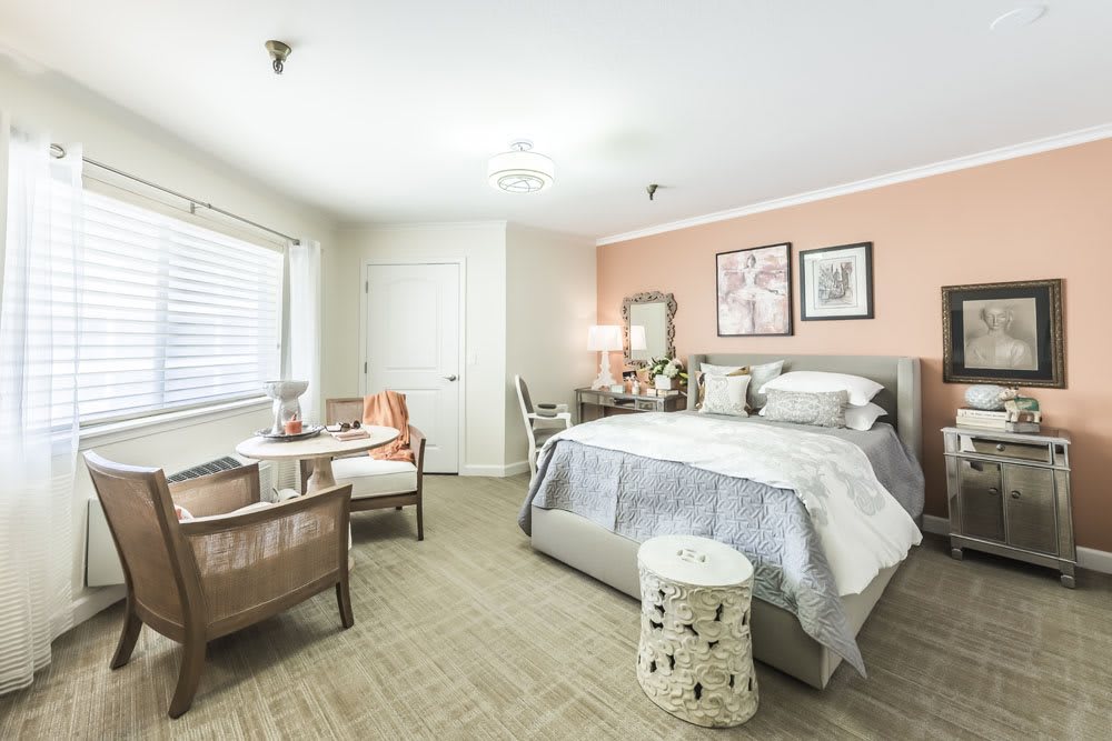 A cozy bedroom featuring pastel-colored walls, a comfortable bed, and stylish furniture.