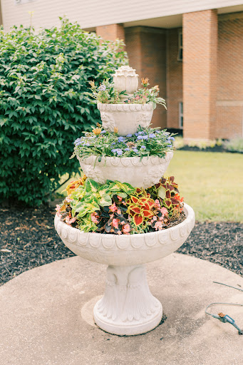 A beautifully arranged tiered fountain planter filled with vibrant flowers, adding charm to the garden.