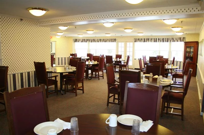 An empty dining room with neatly arranged tables and chairs, set for service.