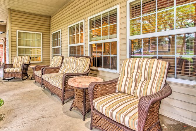 Outdoor patio with wicker chairs and cushions.