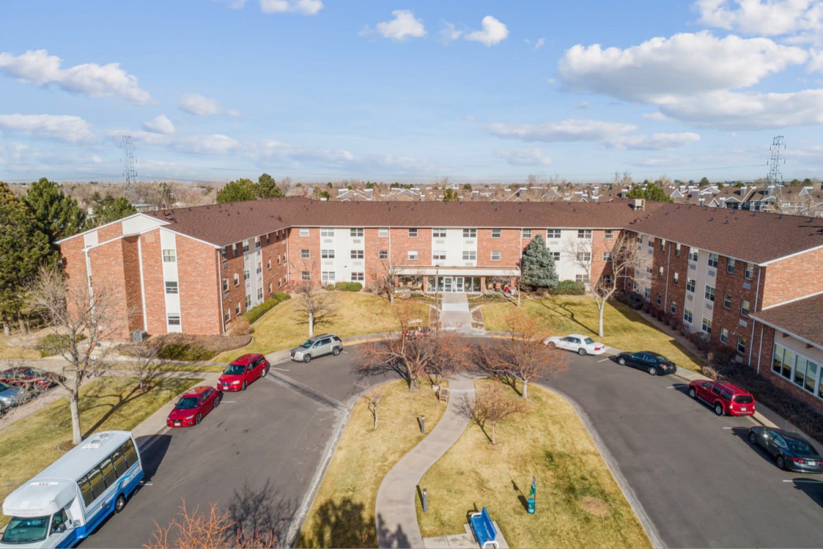 Aerial view of a residential apartment complex with a circular driveway and parking area.