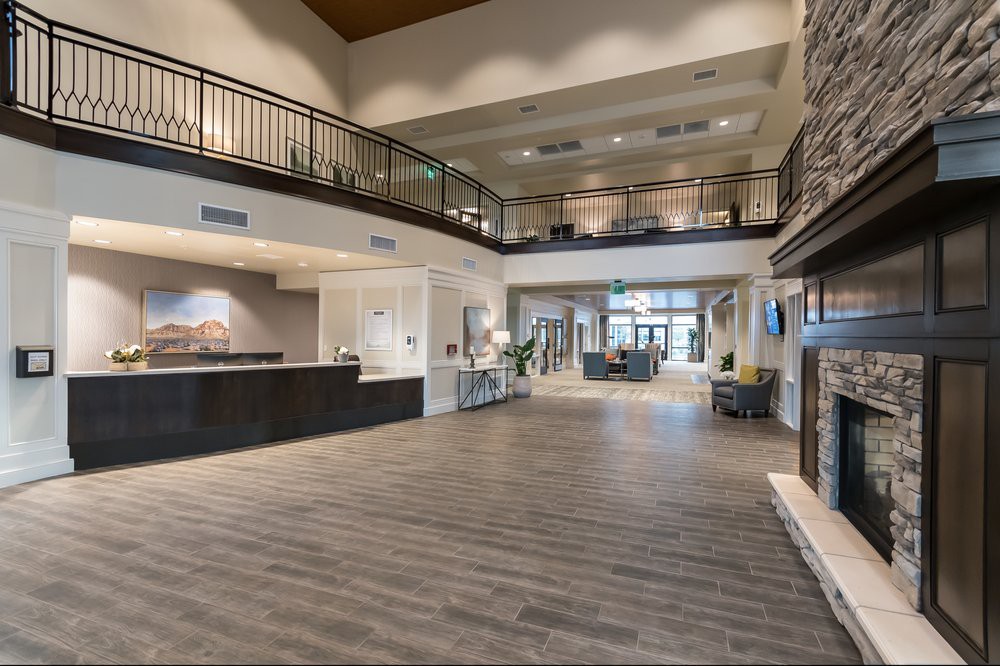 A spacious and modern hotel lobby with a reception desk and seating area.