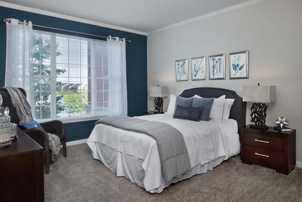 A modern bedroom with stylish decor and a large window.