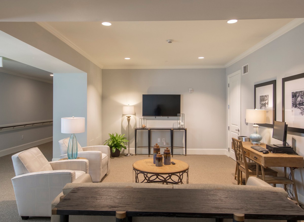 A modern living room featuring a stylish seating area with neutral tones, complete with a television and decorative accents.