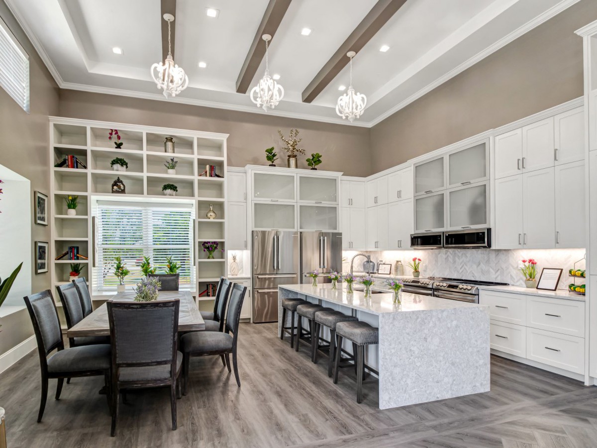 A modern kitchen with an elegant dining area, featuring open shelving and marble countertops.