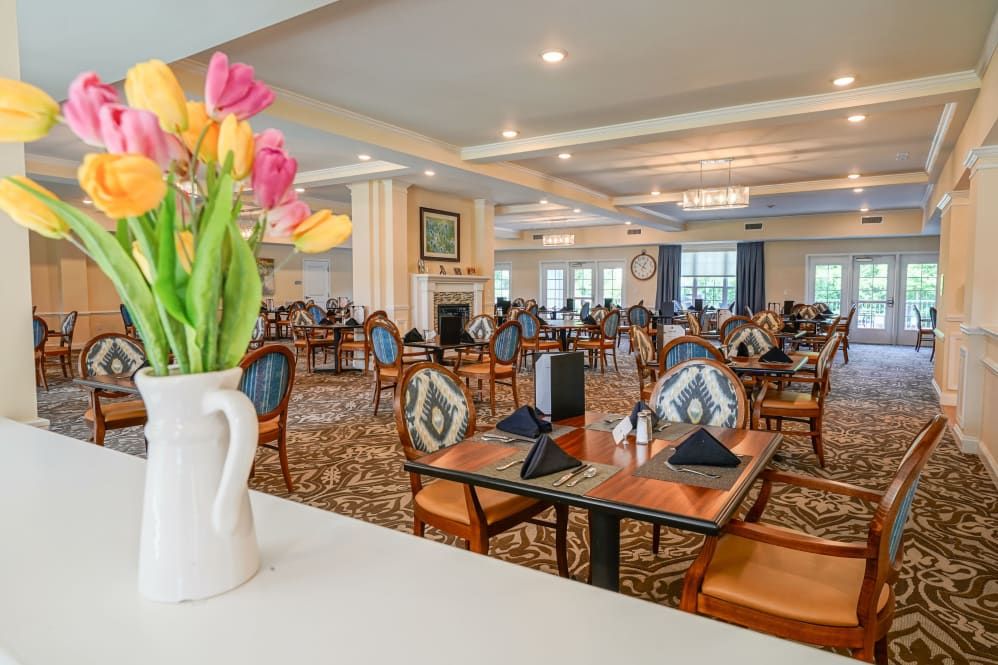 Elegant dining room with neatly set tables and vibrant tulips in a vase.