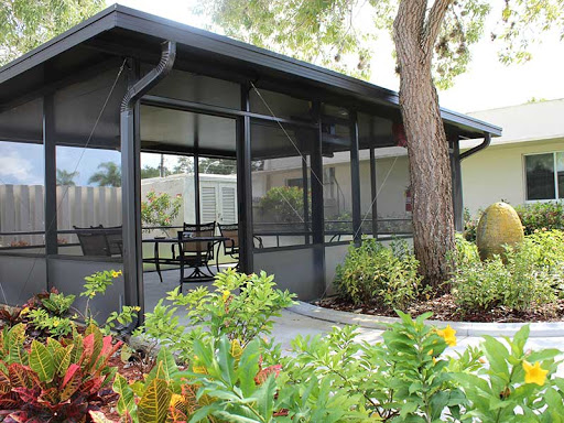 A serene screened porch surrounded by lush greenery, perfect for relaxation.