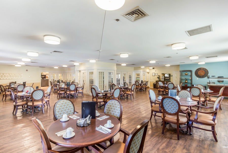 A spacious and well-lit dining area with neatly arranged tables and chairs.