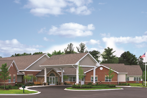 Front view of a modern community facility surrounded by trees and blue skies.