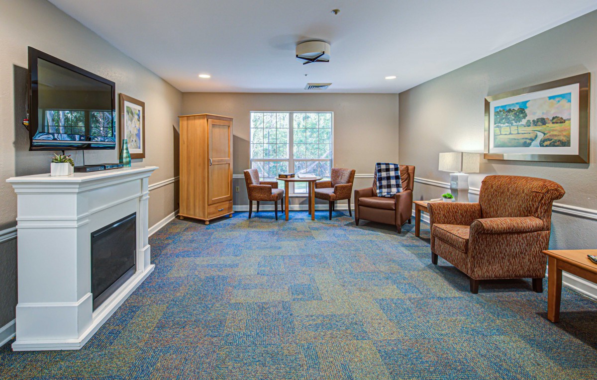 A cozy living room with comfortable seating, a fireplace, and a table by the window.