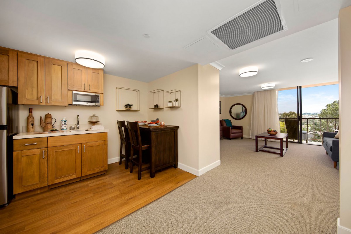 A cozy apartment interior with a kitchenette, dining area, and living room.