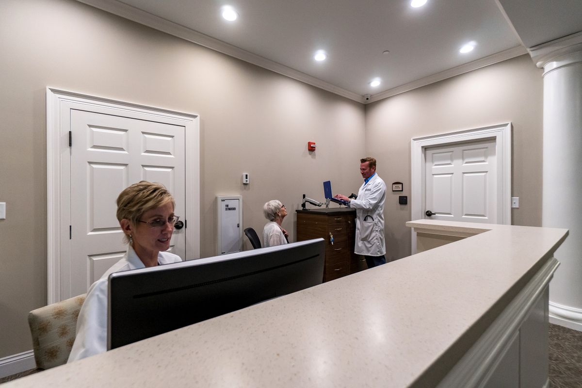 A professional medical office setting with staff members working at computers.