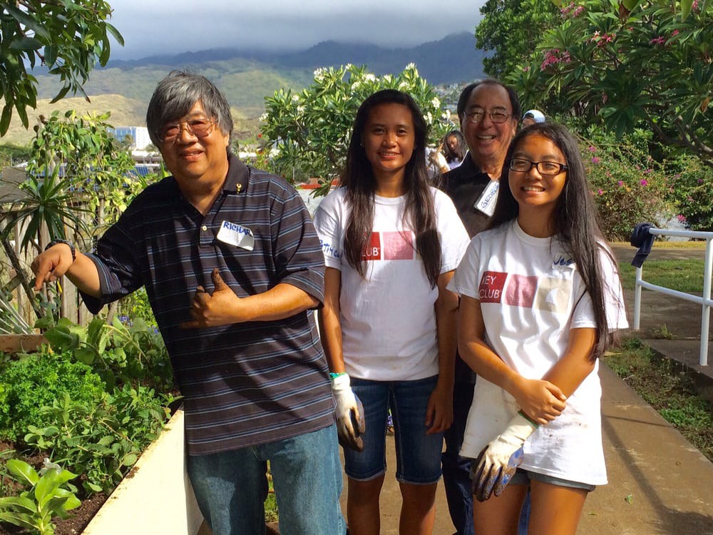 A group of volunteers posing together in a garden.