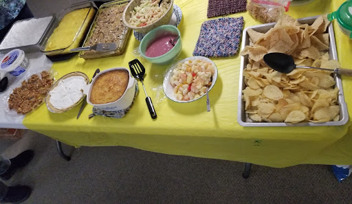 A colorful buffet spread featuring various dishes served on a yellow tablecloth.