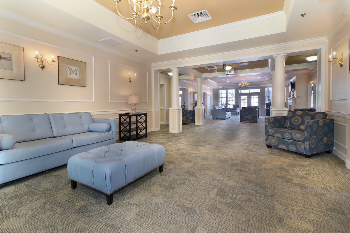 A spacious and elegantly decorated lobby area with comfortable seating and a chandelier.