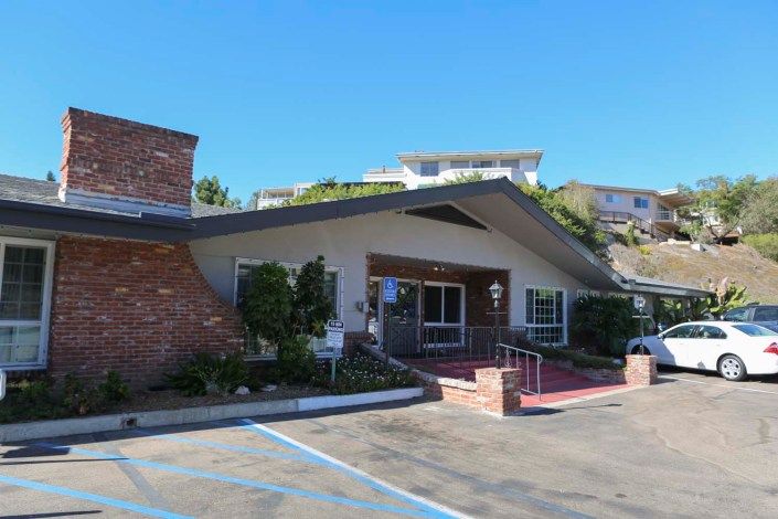 A suburban building with a parking lot and entrance.