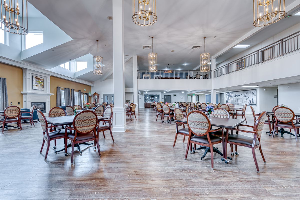 A spacious dining area with elegant chandeliers and modern furnishings.