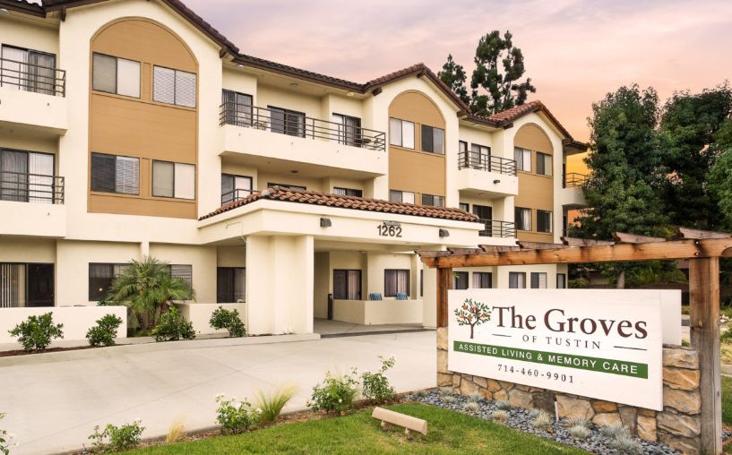 Exterior view of a residential apartment building with a sign in front.
