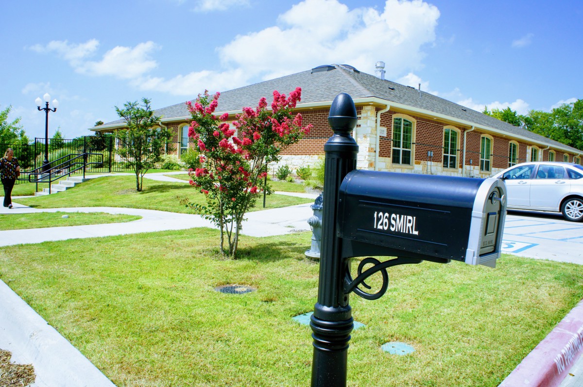 A suburban house with a mailbox surrounded by a landscaped garden.