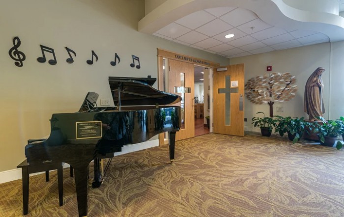 A cozy interior with a grand piano, musical note decorations on the wall, and wooden doors in the background.
