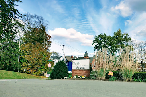 A scenic view of a building surrounded by trees and a clear blue sky.