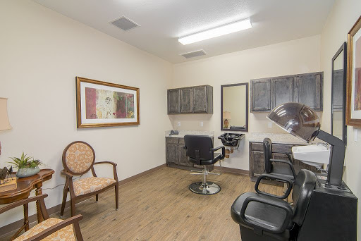 A well-lit hair salon featuring a barber chair, waiting area, and decorative artwork.