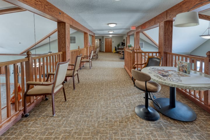 A cozy hallway with seating arrangements and wooden railings.