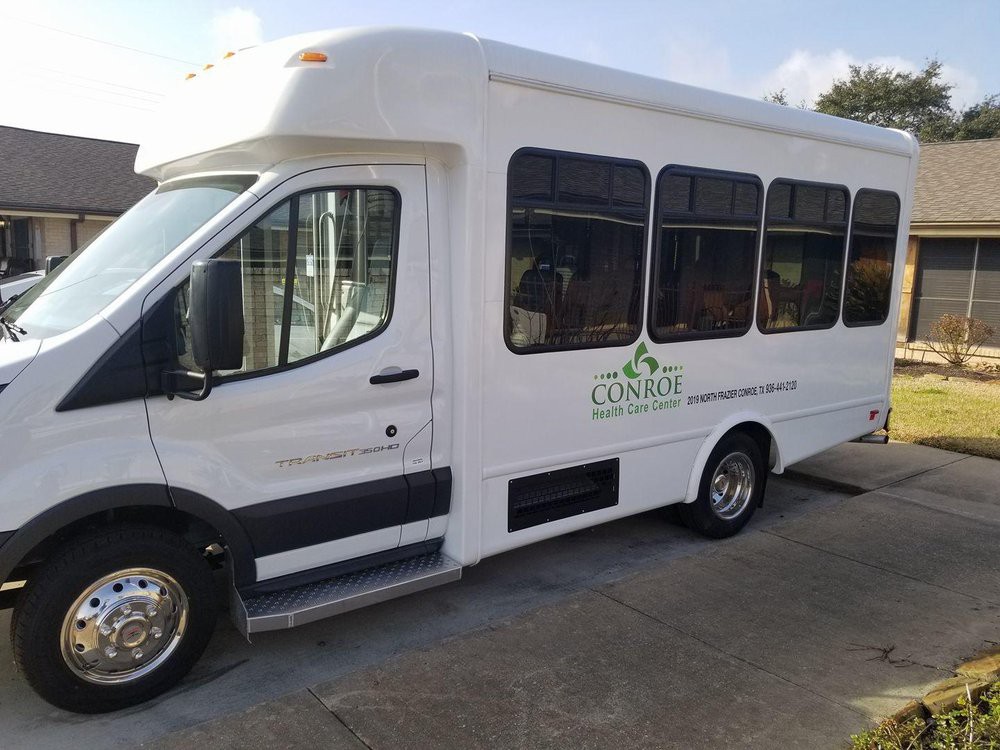 A white minibus parked outdoors.