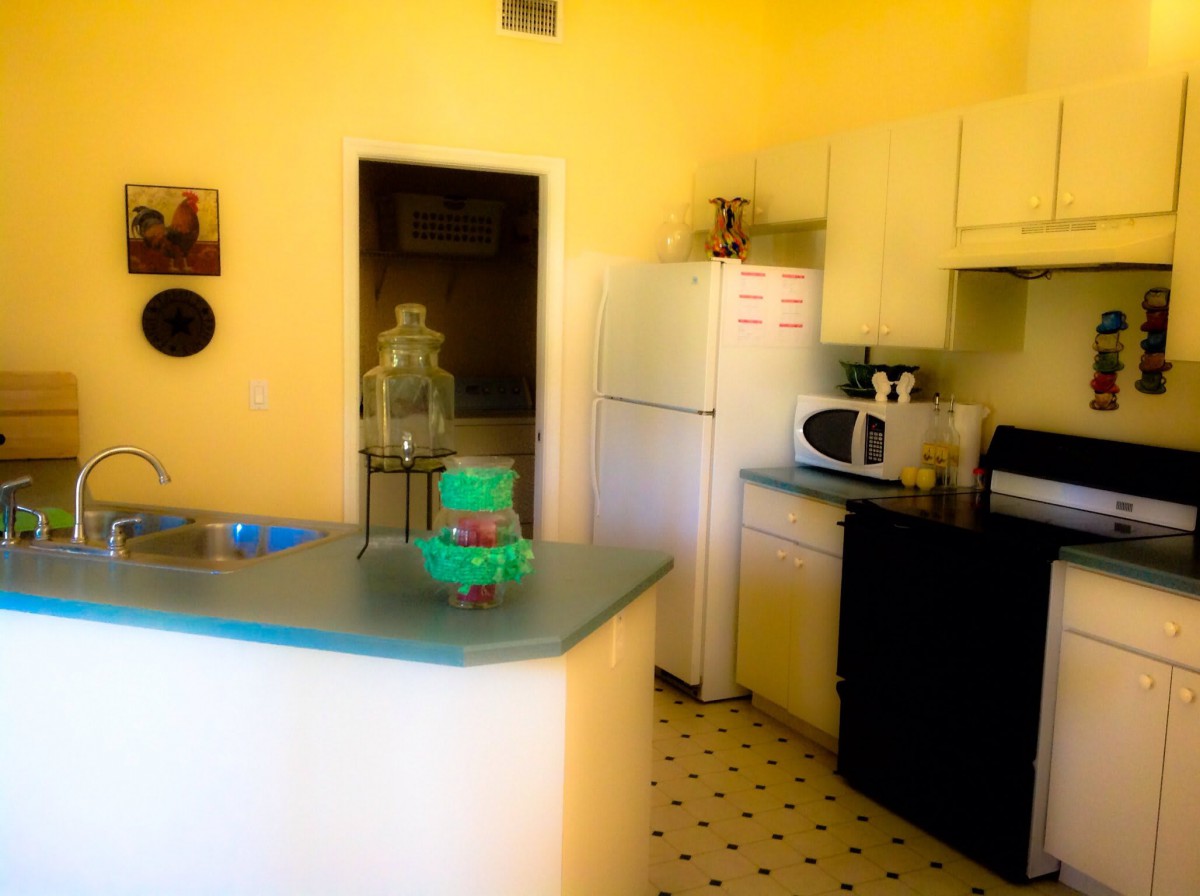 A cozy kitchen with essential appliances and a countertop in a home setting.