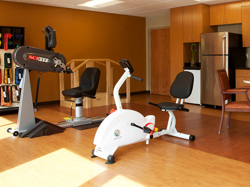 A well-equipped fitness space featuring a recumbent bike and other exercise machines.